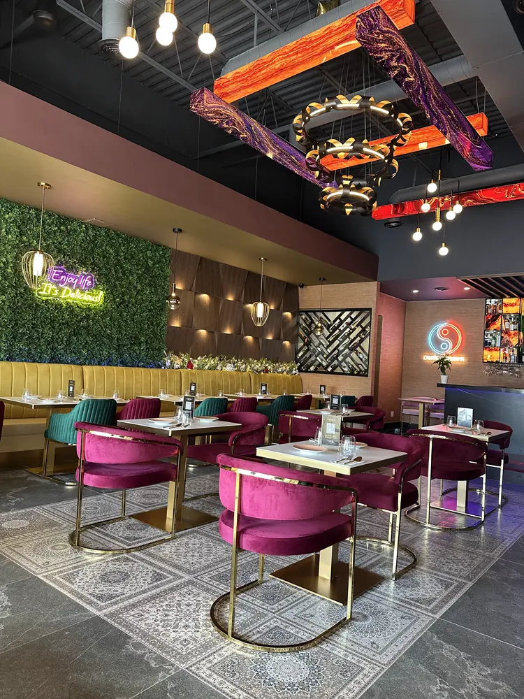 The dining room set for service — jewel-toned chairs on a patterned floor