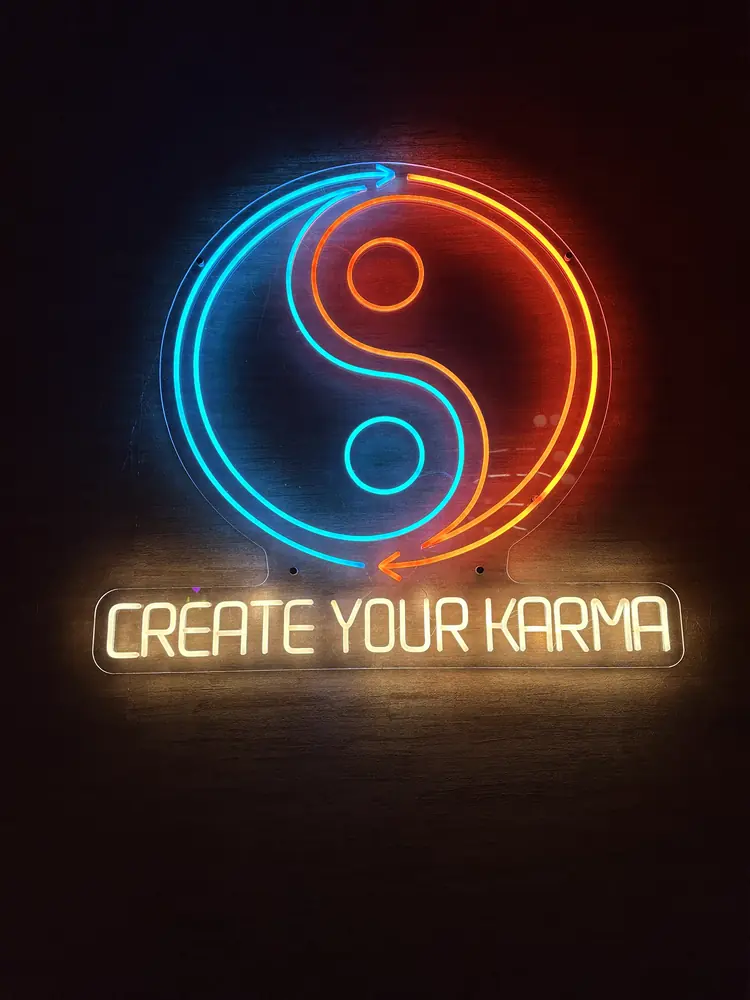 The neon yin-yang sign reading ‘Create Your Karma’