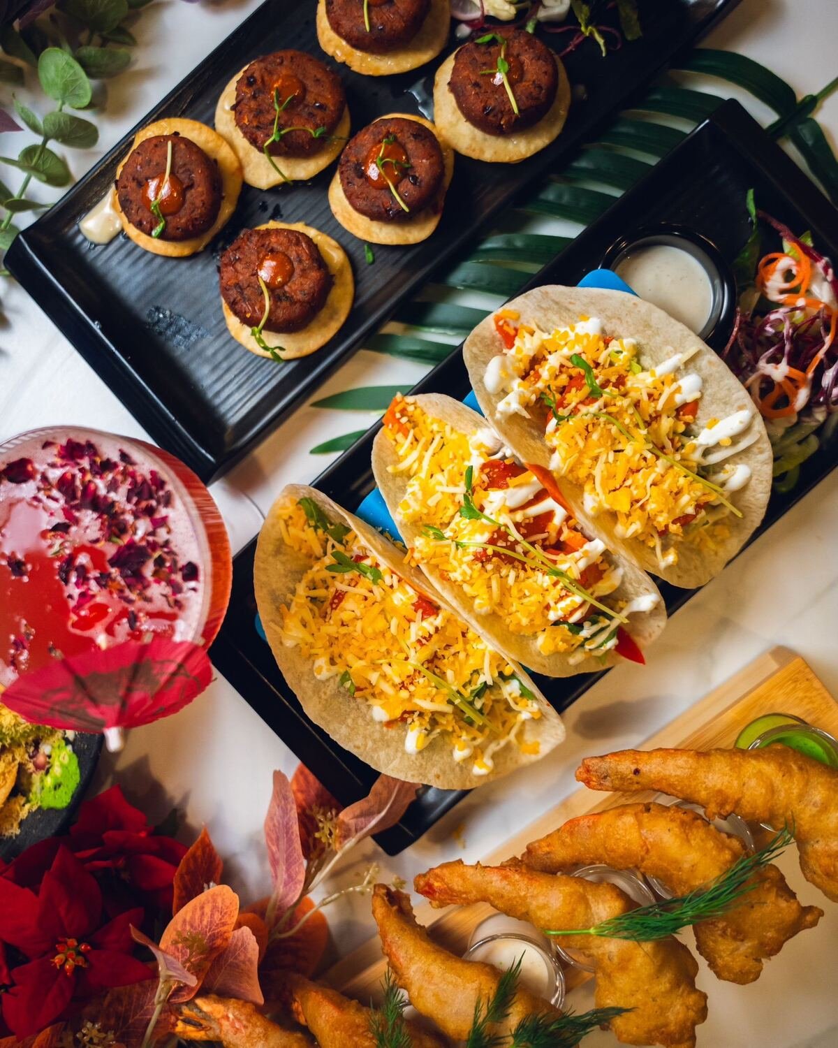 Sharing platter of Delhi street tacos, kebabs and a garnished cocktail at Karma